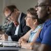 Three LTSS students listening to professor in a classroom